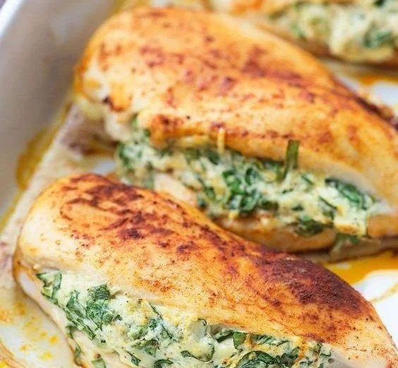 Plate of spinach stuffed chicken breasts garnished with herbs