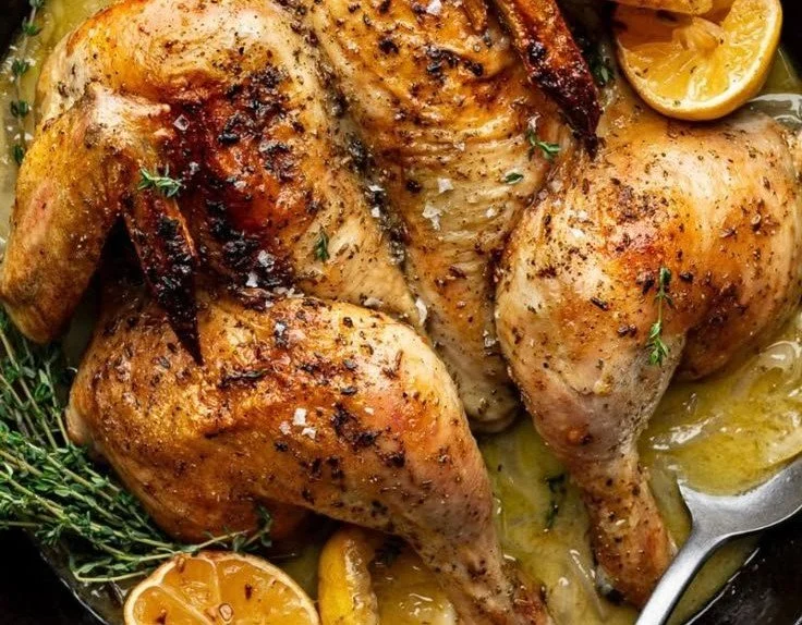 Skillet-roasted lemon chicken garnished with fresh herbs on a white plate