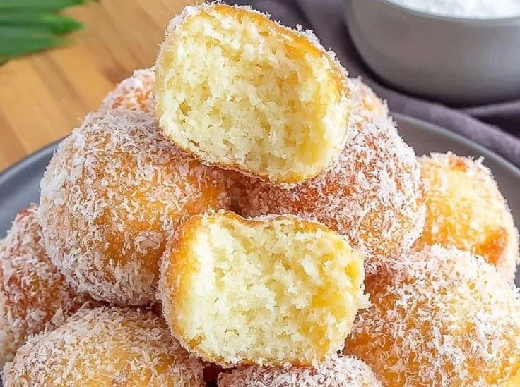 Luftige Quarkbällchen auf einem Teller, frisch gebacken und lecker verziert.